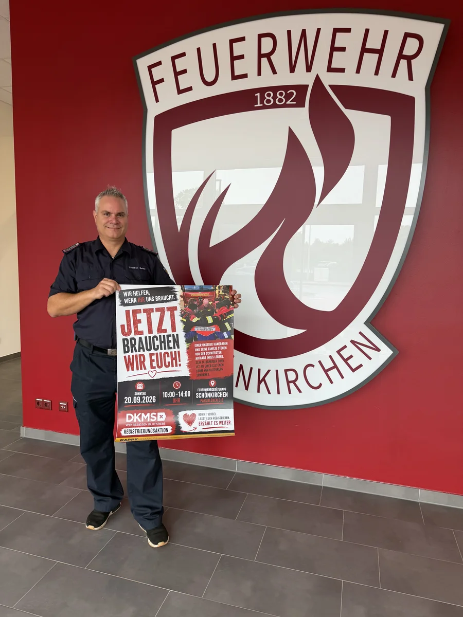Gruppenführer Thorben Seidel vor dem Wappen der FF Schönkirchen im Feuerwehrhaus